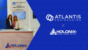 Two team members from Atlantis Engineering and Holonix at their co-branded booth during the BI-MU 2024 exhibition, presenting solutions in predictive maintenance, IoT, and digital asset management.
